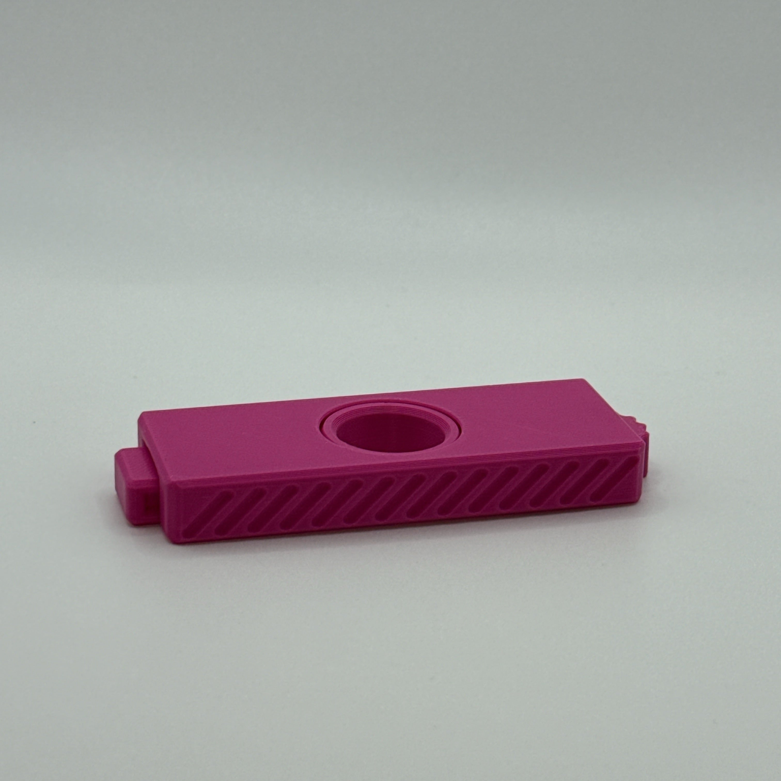 Magenta Fidget Fusion fidget toy on a light gray background