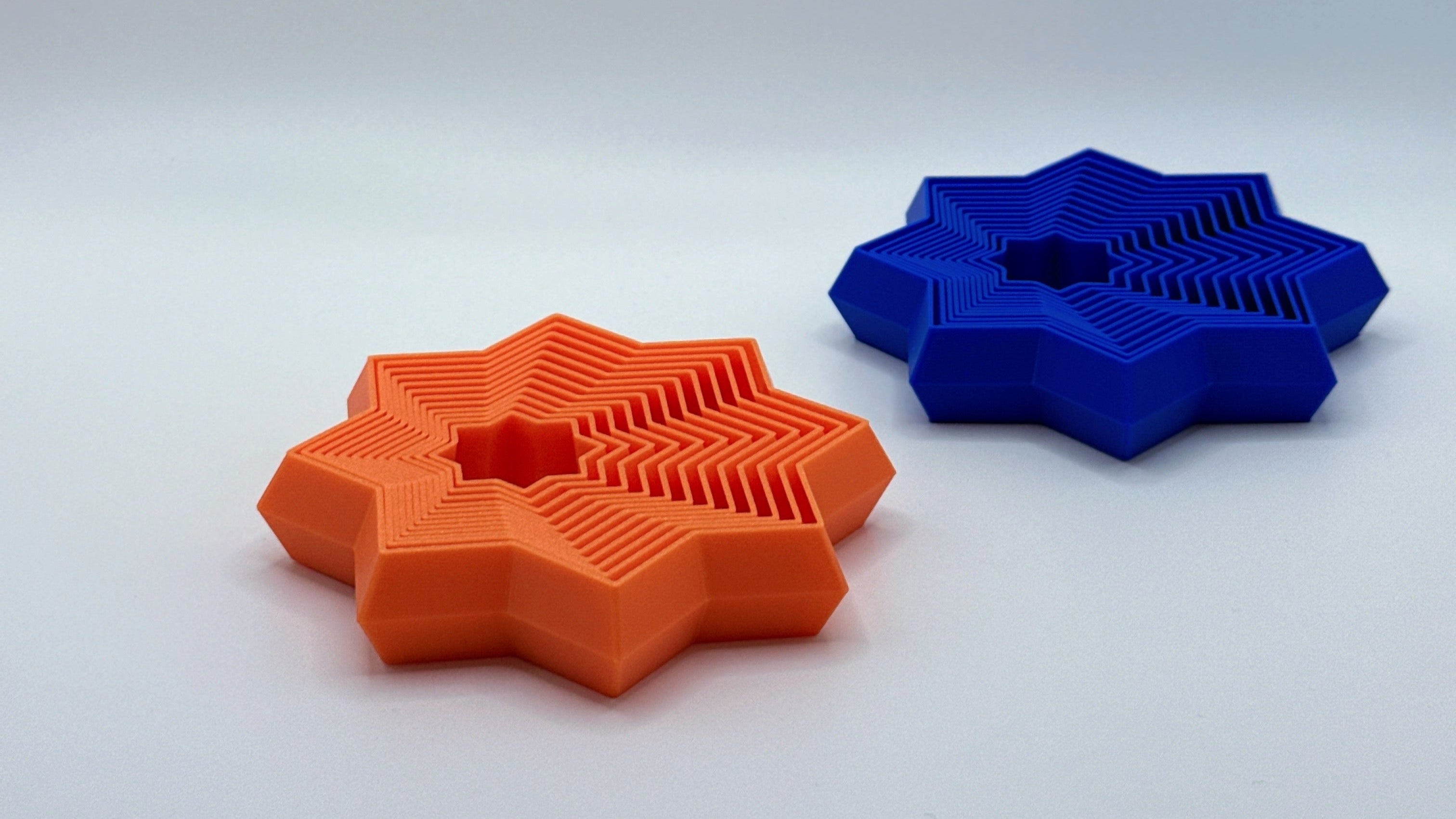 Orange and blue Supernova star-shaped fidget toy on a light gray background.