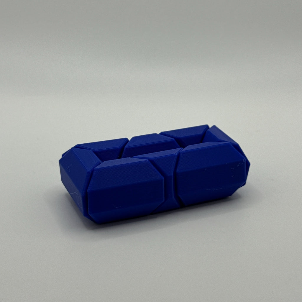 Blue Infinite Twist hexagon-shaped fidget toy on a gray background
