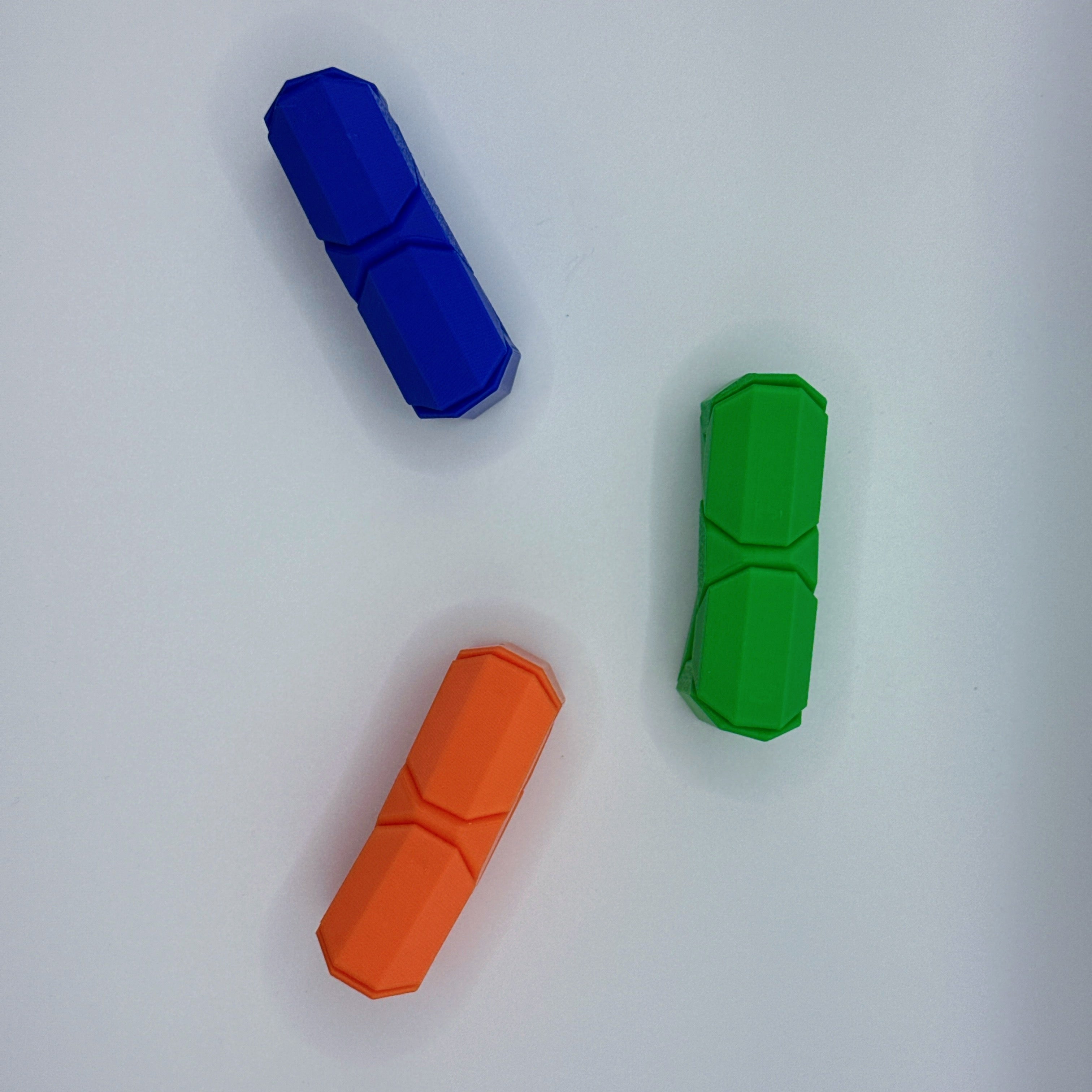 Top down view of a blue, green and orange Infinite Twist hexagonal shaped fidget toy on a white background.