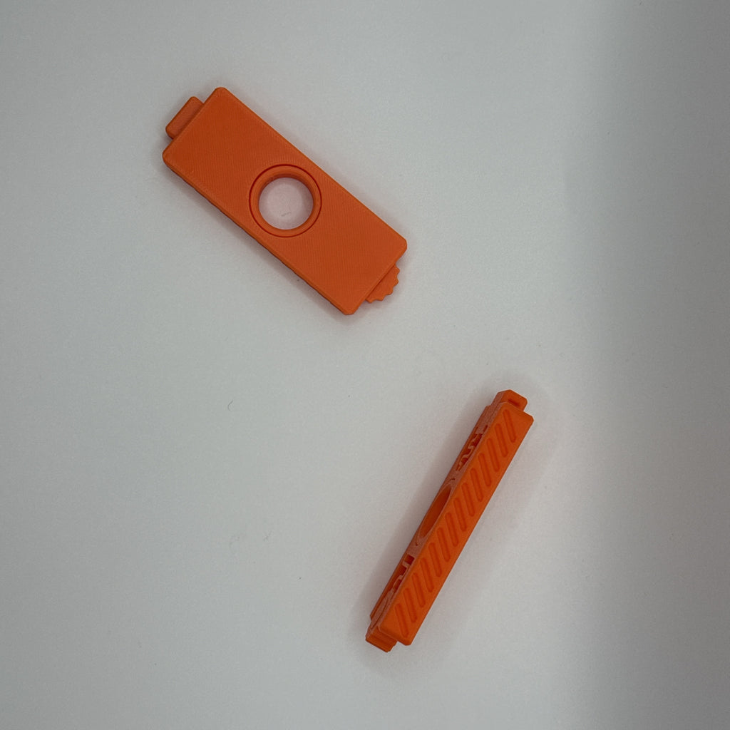 Two orange Fidget Fusion fidget toys in a side and top down orientation on a white background.