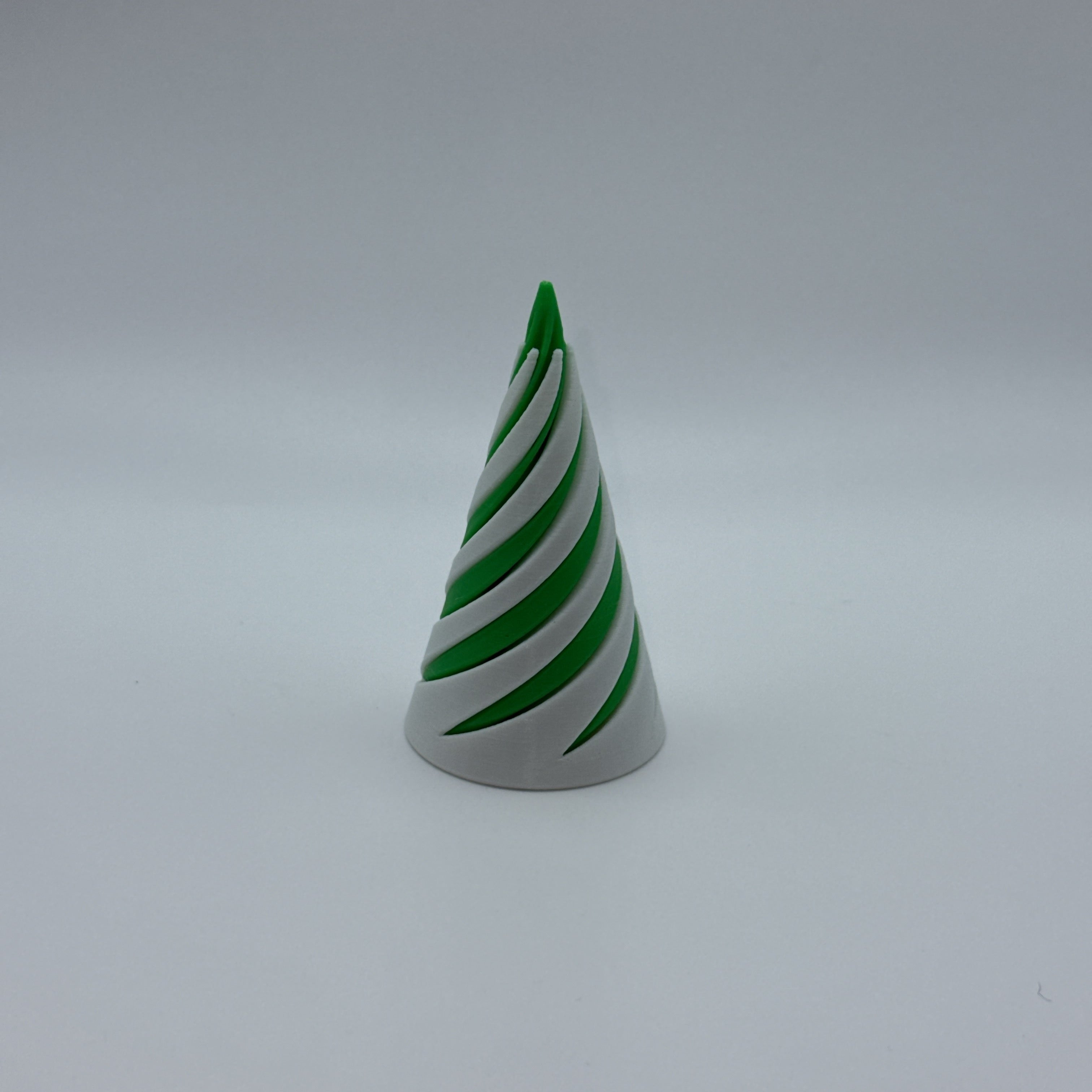 Green and white medium Spirally striped cone-shaped fidget toy on a gray background