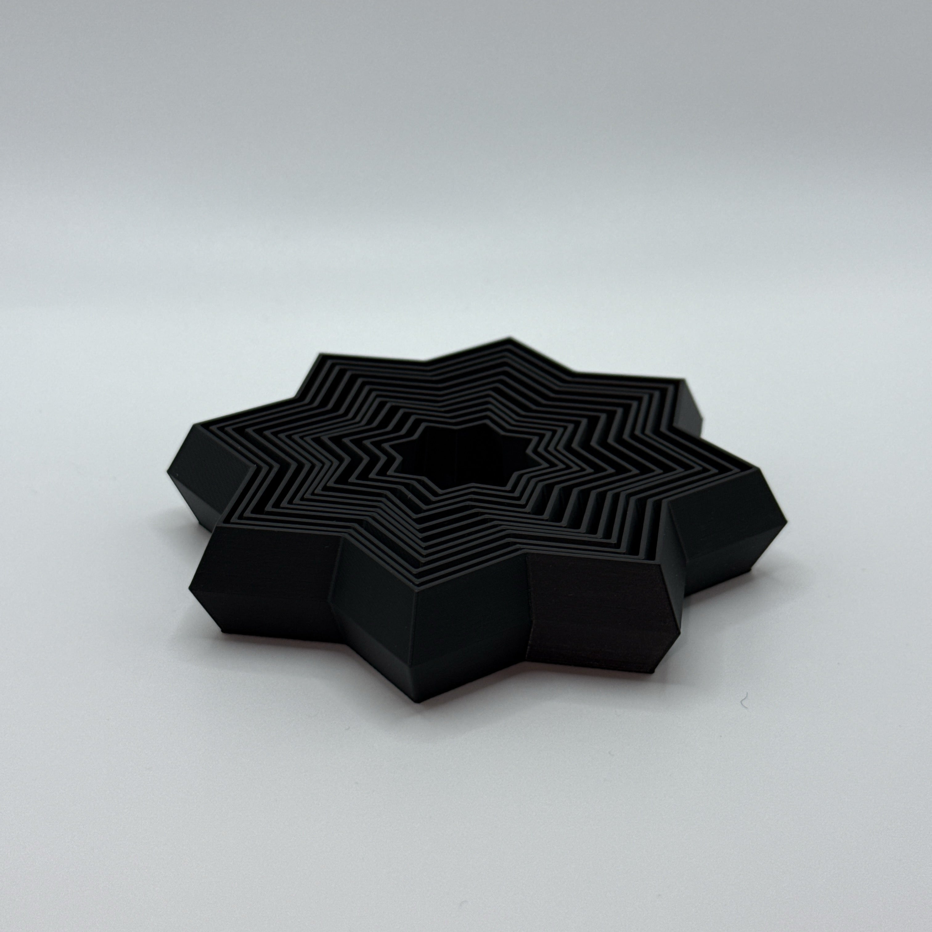 Black Supernova star-shaped geometric fidget toy on a white background.