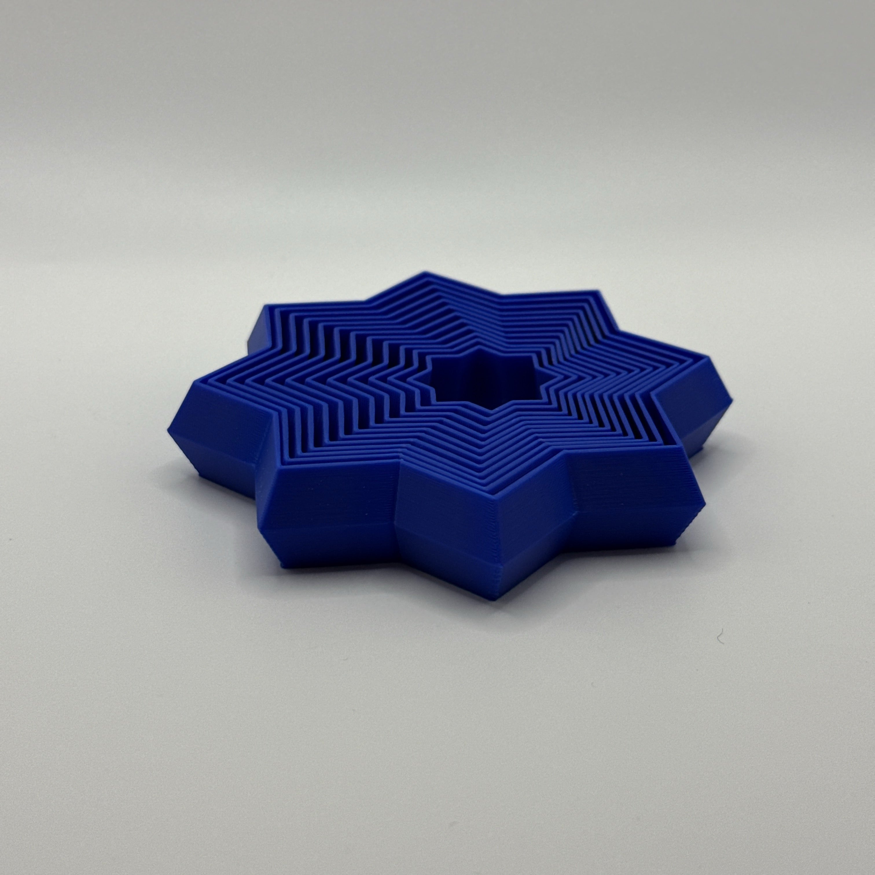 Blue Supernova star-shaped geometric fidget toy on a white background