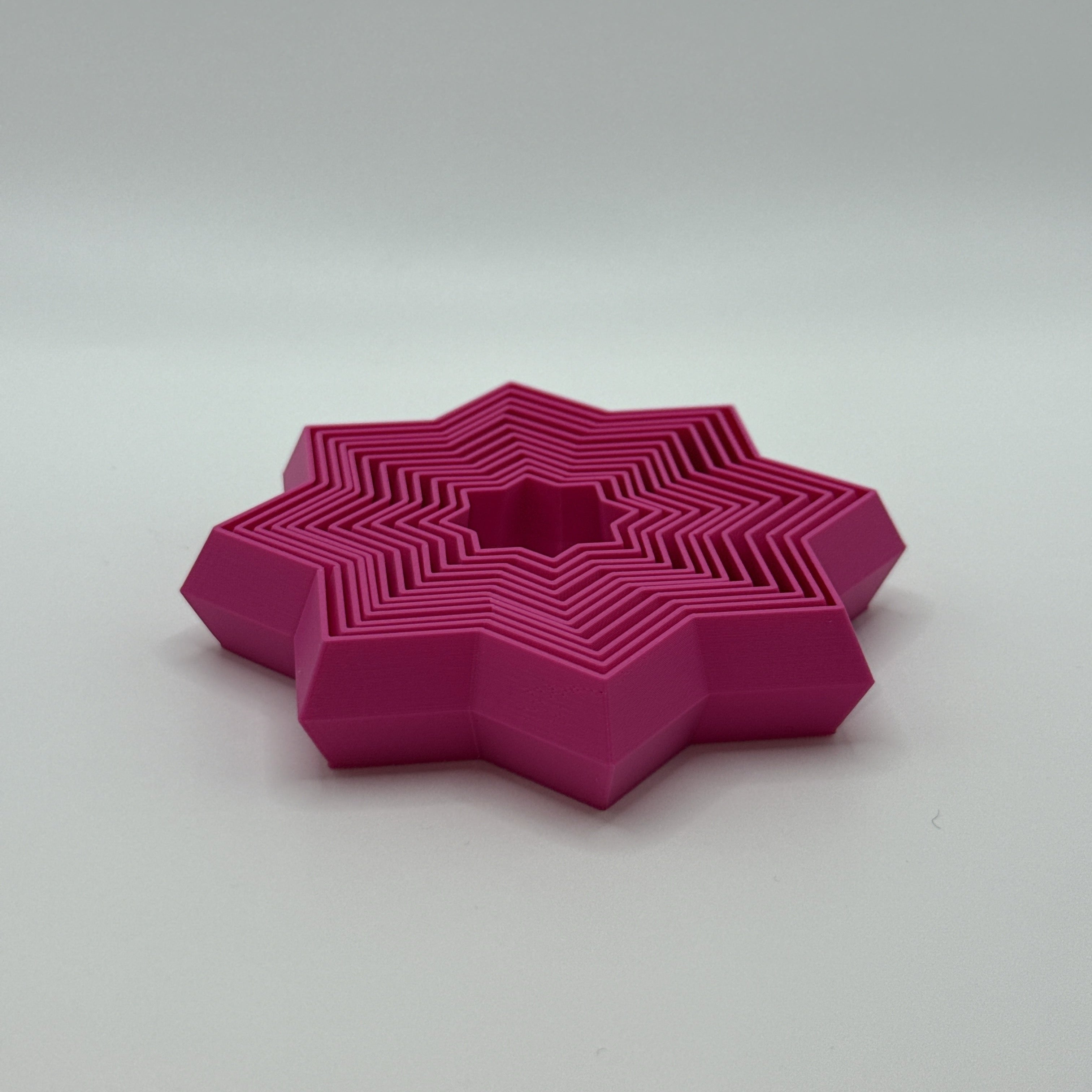 Magenta Supernova star-shaped geometric fidget toyon a white background